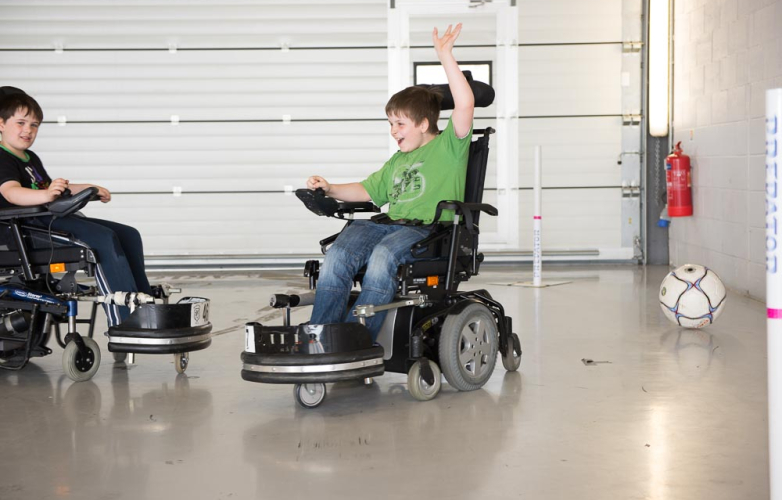 Powered wheelchair lad celebrating a goal