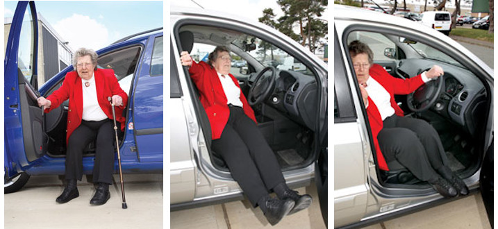 A woman getting into a car by swinging her legs around after she has sat down